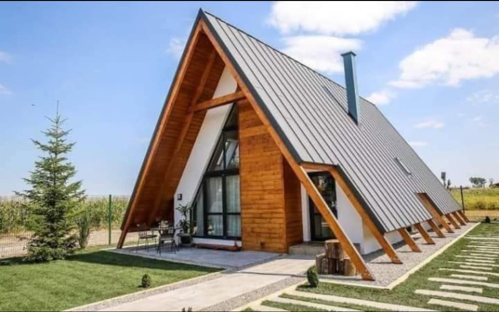 Cabană A-Frame exterioară — acoperiș metalic, lemn natural și terasă