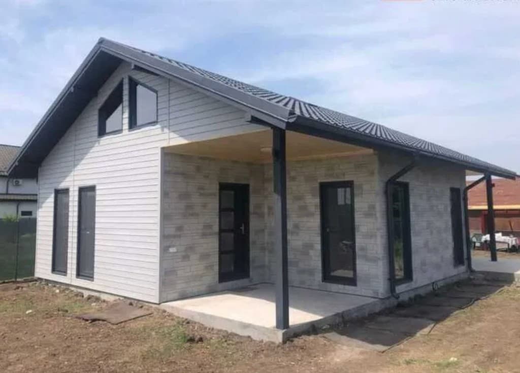 Casă modulară cu terasă acoperită — finisaje premium din siding și piatră decorativă